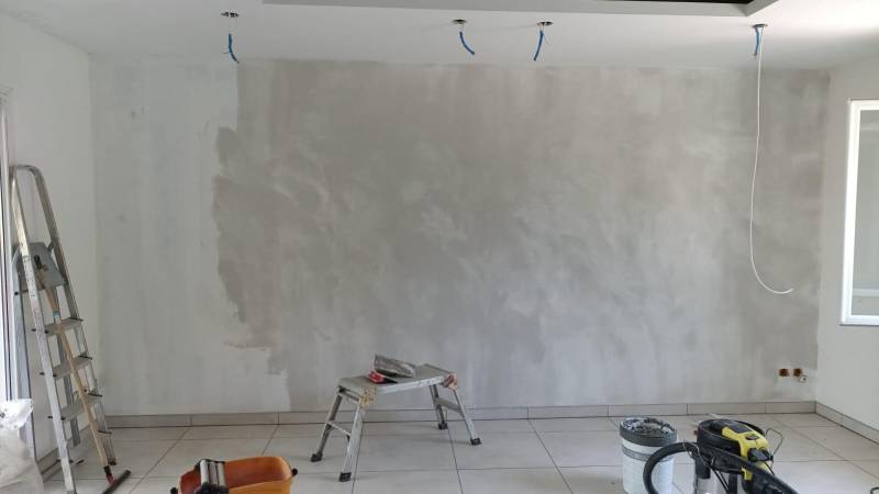 Application d’un enduit de lissage pour uniformiser les murs avant peinture – Chantier Green House à Aix-en-Provence.